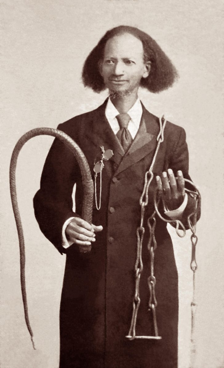 a black man holding a whip and chains
