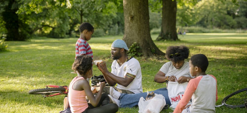 a family enjoying a picnic surrounded by trees