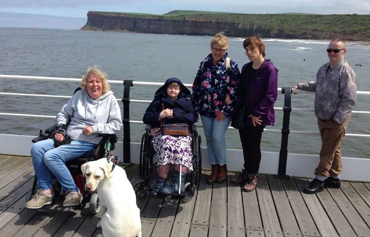 Four people and a dog on a boat deck