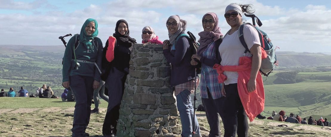 Group of women gathered around trig point