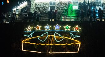 a pie made of lights on a harbour wall in front of a pub