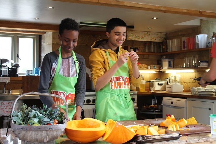 two young men cooking in a farmhouse kitchen