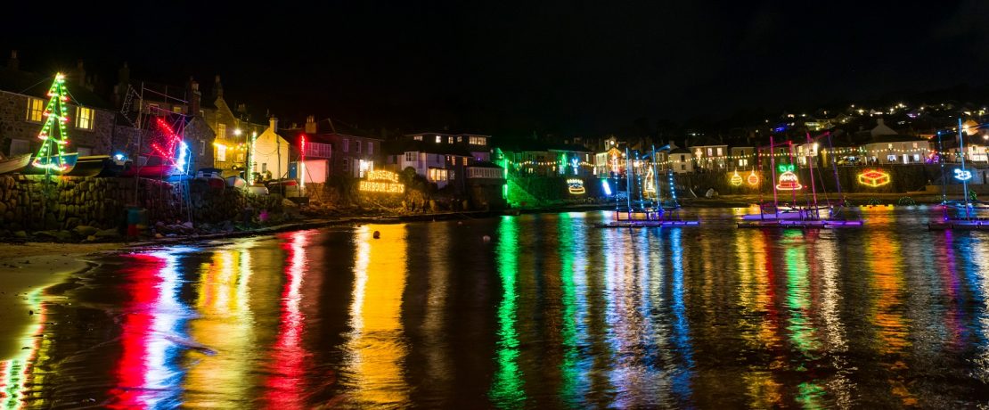 Christmas lights reflecting on the water in a harbour