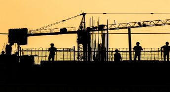 Builders silhouetted against a horizon