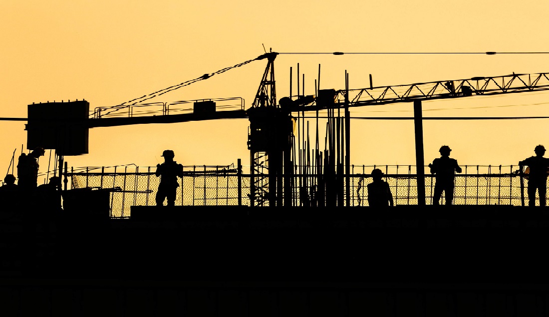 Builders silhouetted against a horizon