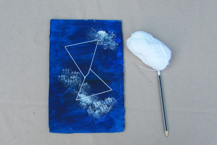 Blue card with painted clouds and a yarn constellation