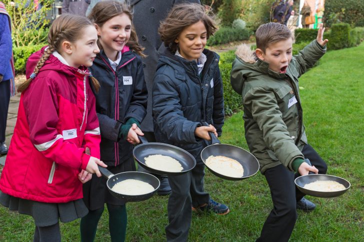 Children practising tossing pancakes before a race