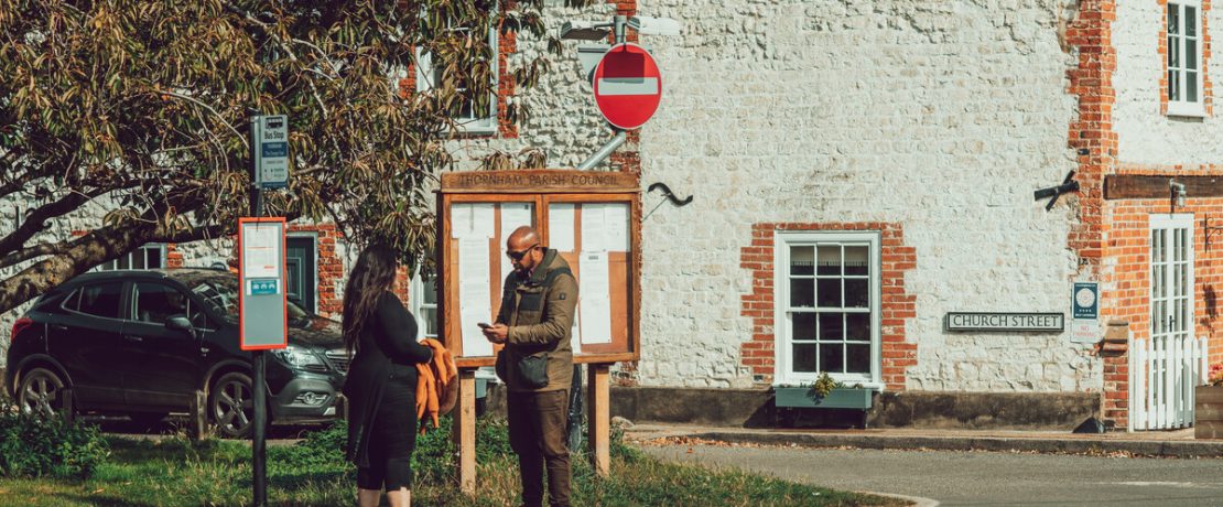 Couple reading something while waiting at village bus stop