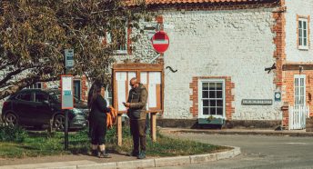 Couple reading something while waiting at village bus stop