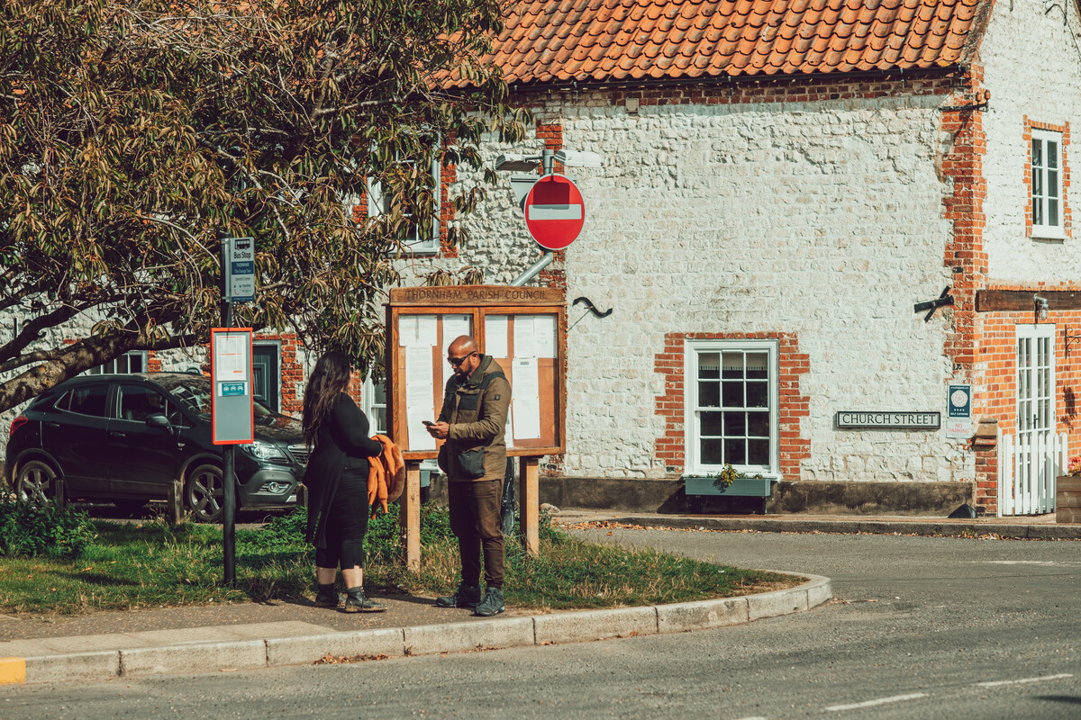 Couple reading something while waiting at village bus stop