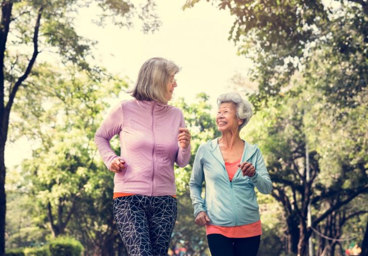 Two women in sporty kit walking briskly outdoors