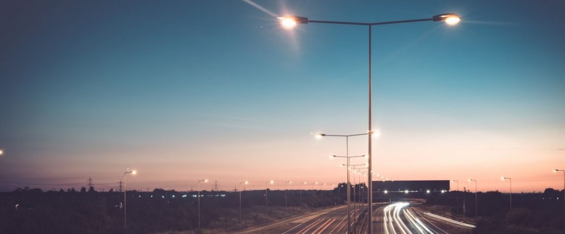 A motorway lit by streetlights at night