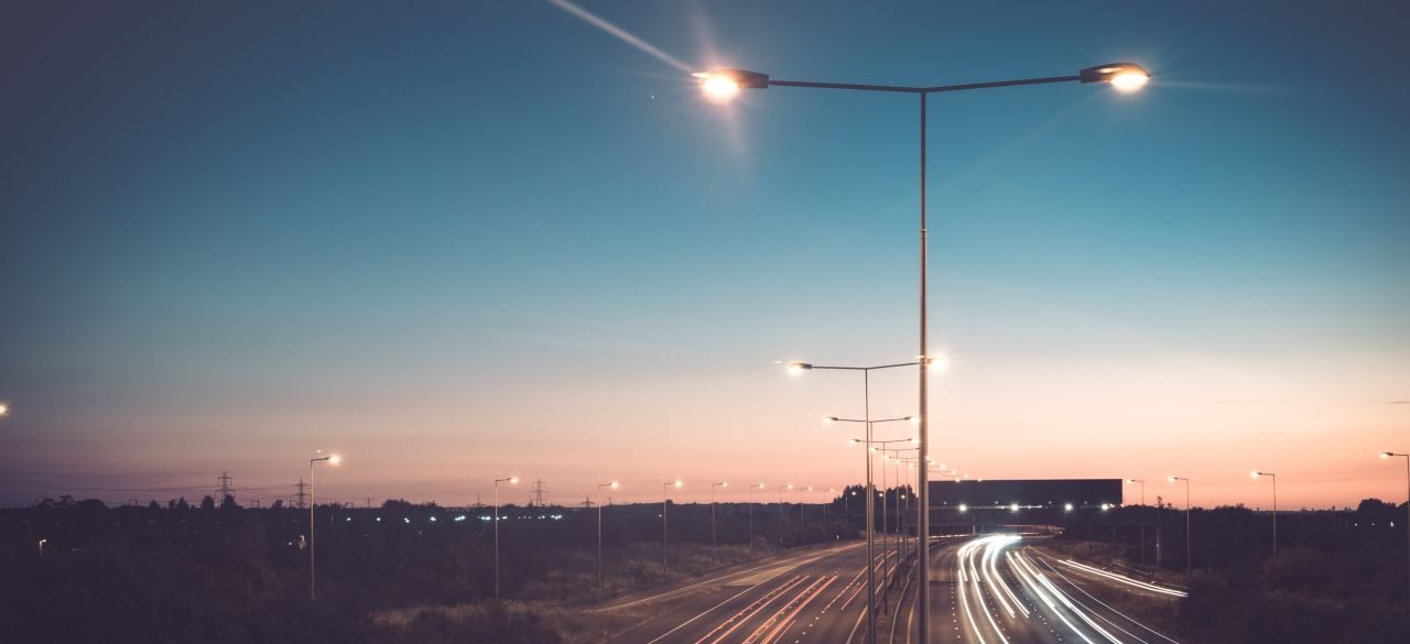 A motorway lit by streetlights at night