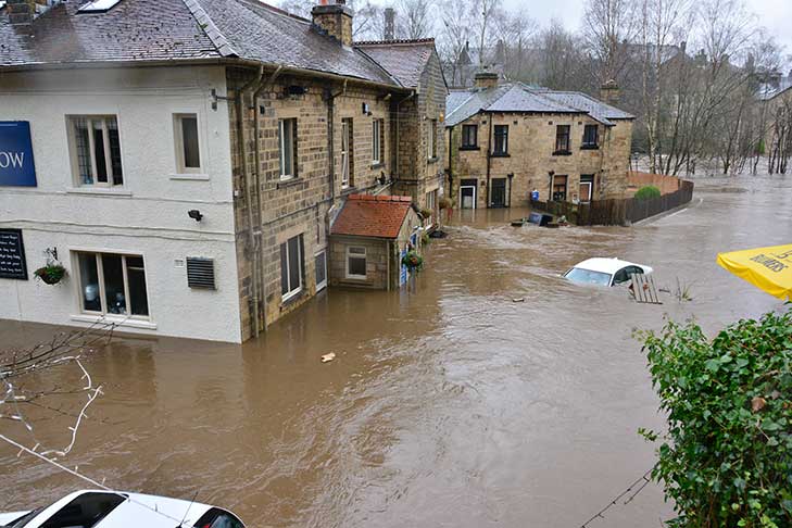 High water around buildings and almost submerging a car