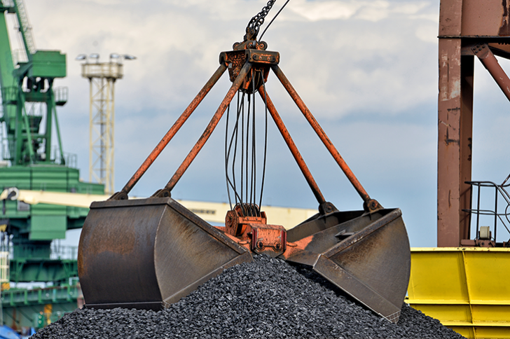 A pile of coal being picked up by a machine scoop