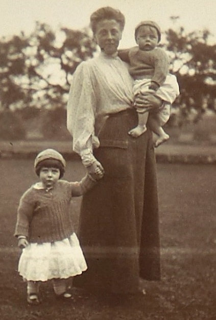 a black and white image of a woman and two young children