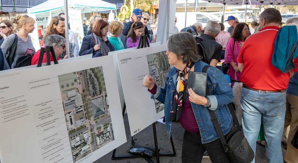 Crowds of people viewing outdoor boards showing new buildings