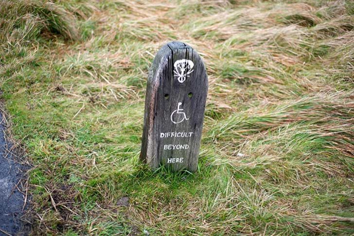 A sign with a wheelchair icon stating 'difficult beyond here'