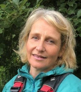 A woman in turquoise anorak with backpack