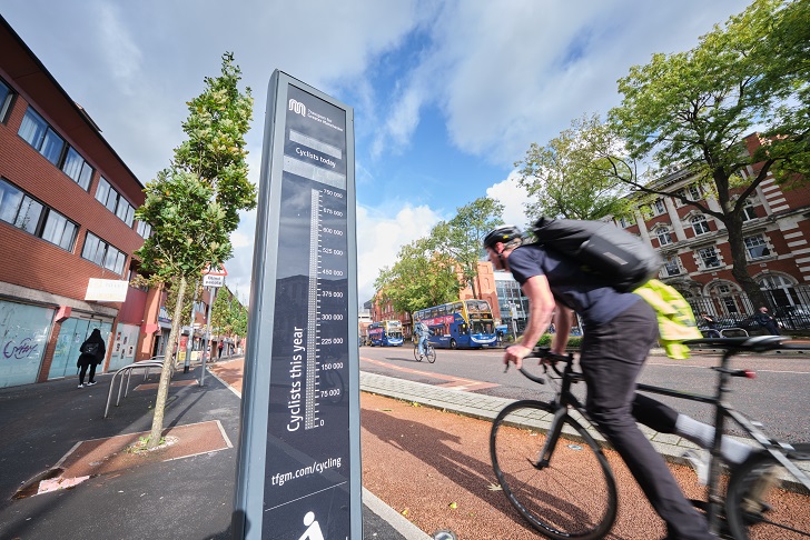 A man using a red cycle path in a city