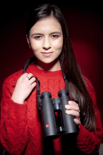 A girl in red holding binoculars