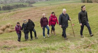 A group of walkers climbing a grassy hill