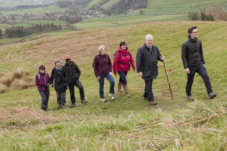 A group of walkers climbing a grassy hill