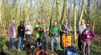 A mixed group of people with hot drinks in woodland