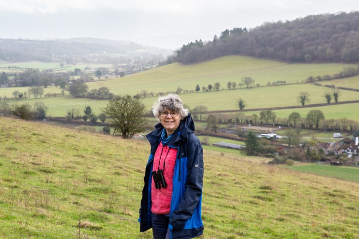 A woman in an anorak in a green valley