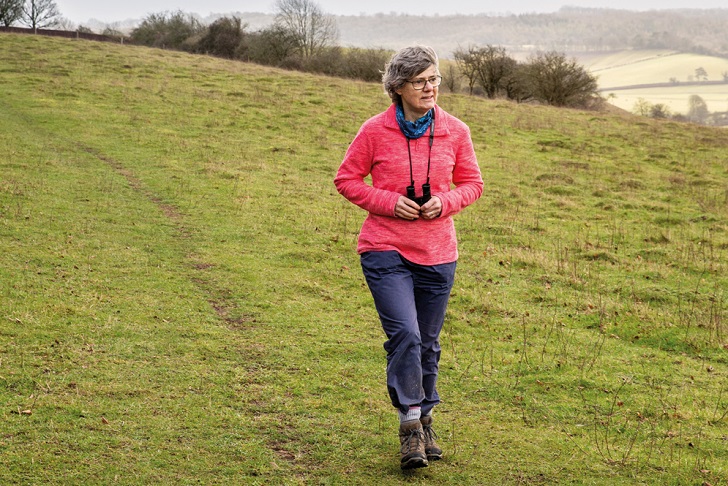 A woman walking with binoculars