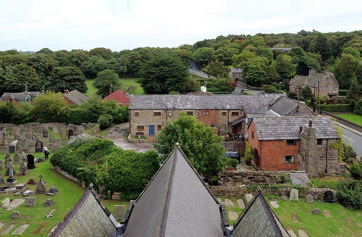 A church roof and surrounding village viewed from the tower