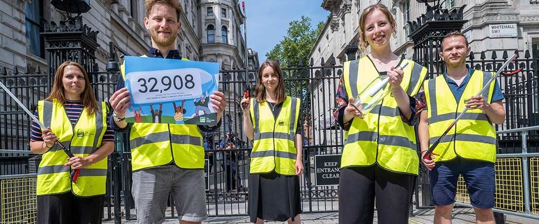 People wearing CPRE-branded high visibility jackets stand in front of Downing Street