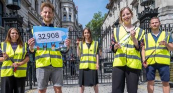 People wearing CPRE-branded high visibility jackets stand in front of Downing Street