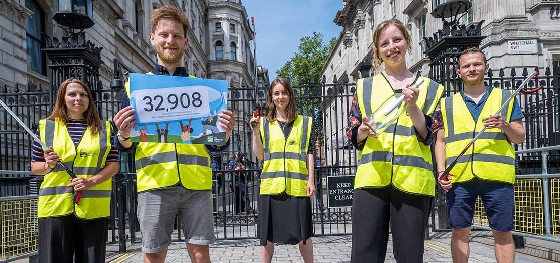 People wearing CPRE-branded high visibility jackets stand in front of Downing Street