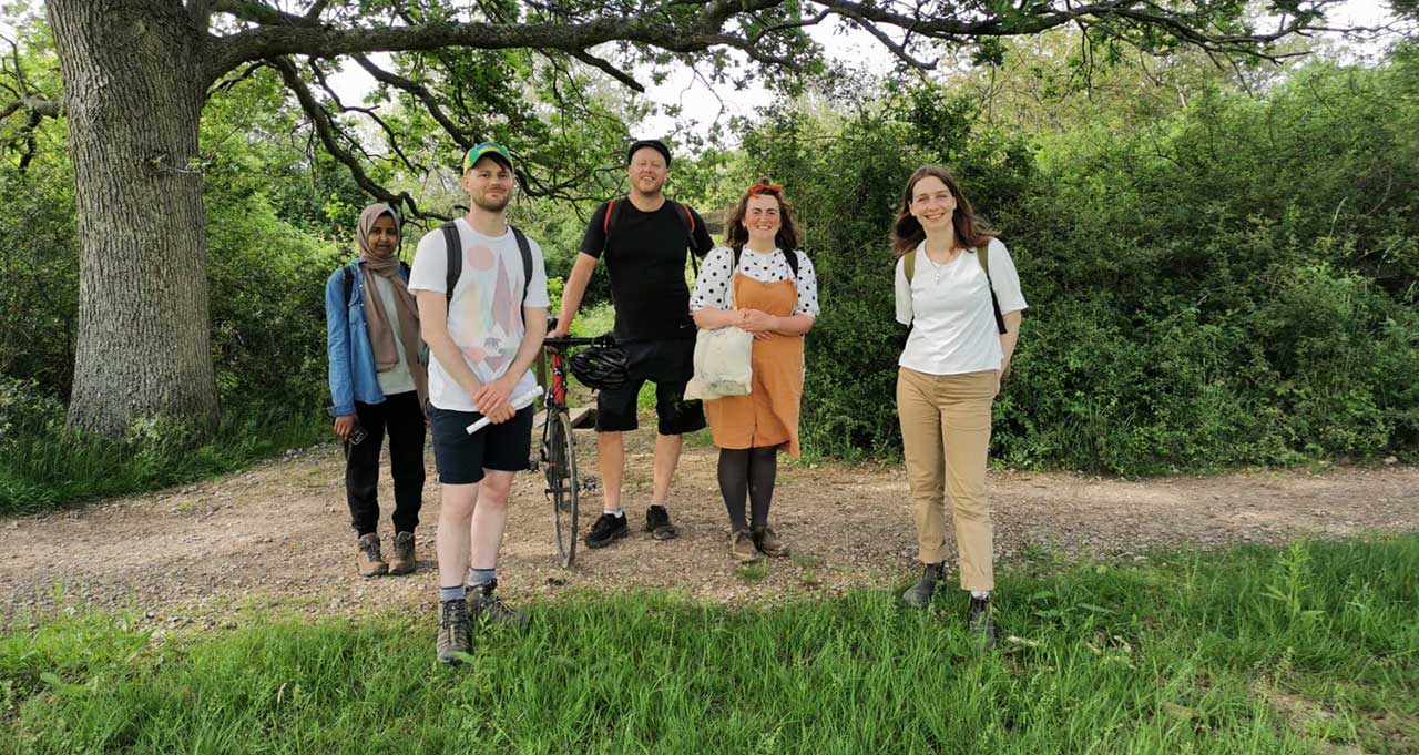 Men and women of various ages stand outdoors in comfortable clothes