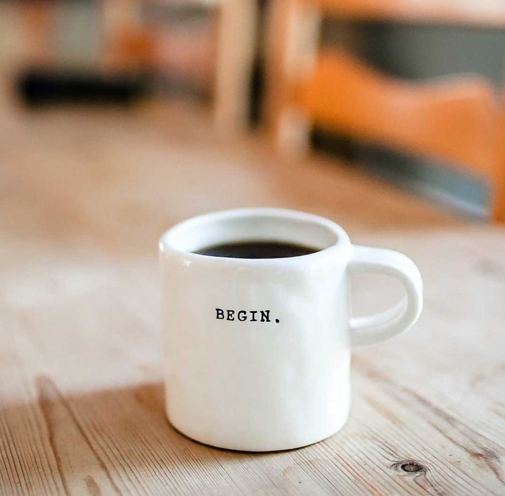 White china mug with the word begin on it