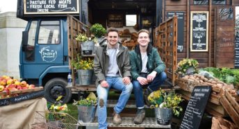 Two men serving at a mobile farm shop