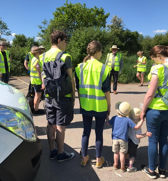 A group of litter pickers and children on a sunny day