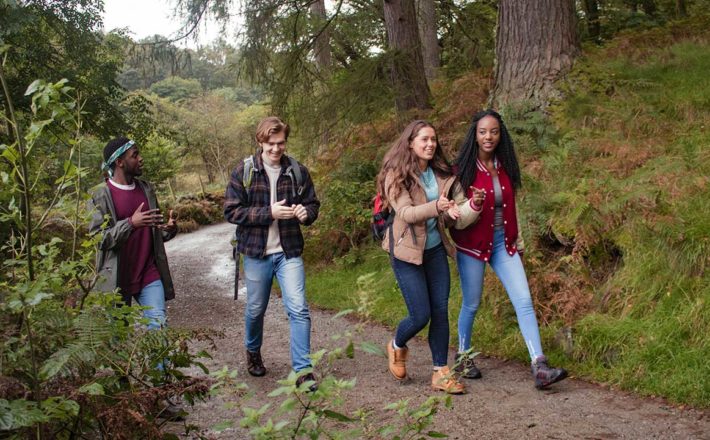Two young women and two young men on a walk on a rural path