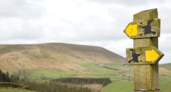 Footpath signs with Pendle Hill in the background above the village of Barley, in the Borough of Pendle Lancashire