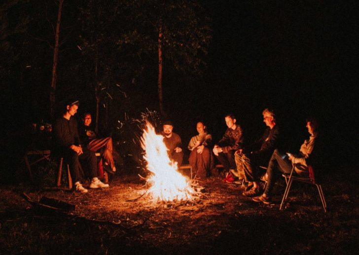 A photo of a crowd of people gathering around a bonfire
