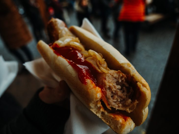 A photo of someone holding a hotdog with ketchup and mustard