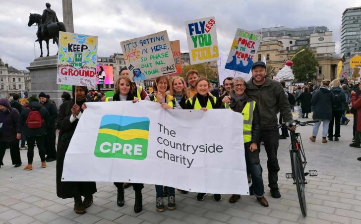 A row of people holding banners and signs in Trafalgar Square, London