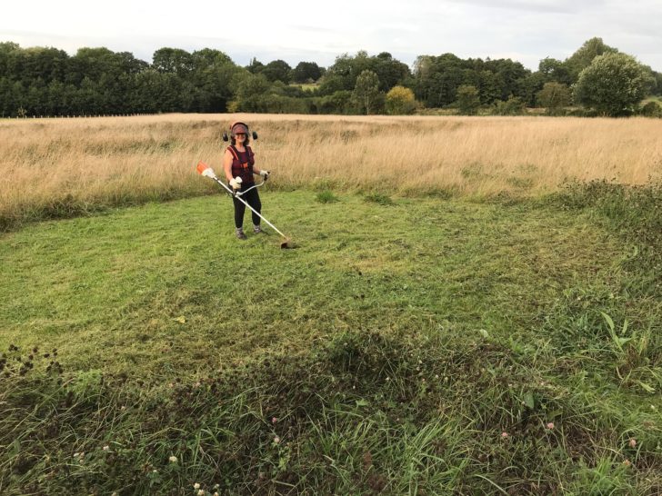 Sheena working in the field with a grass trimmer