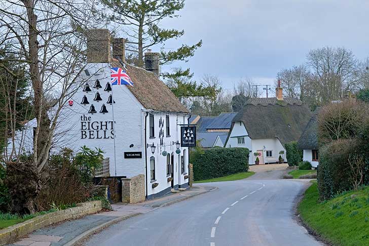 A white-walled country pub on a rural road