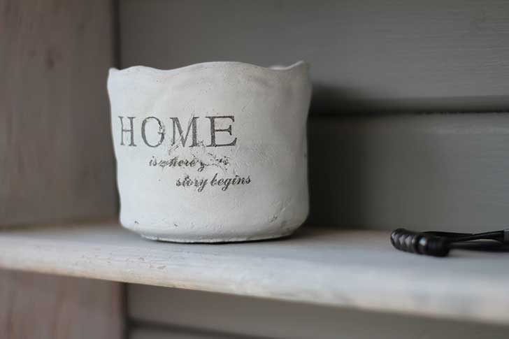 Plant pot with 'home is where your story begins' painted on
