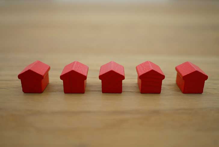 A row of identical red toy houses