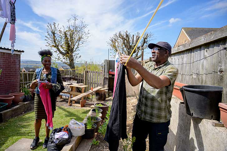 Two people hanging out washing in rural garden