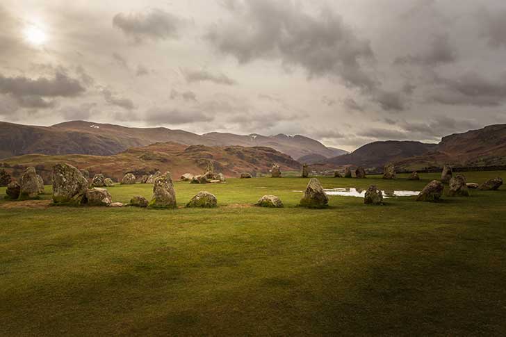 A circle of low oval stones with a dramatic hill range behind