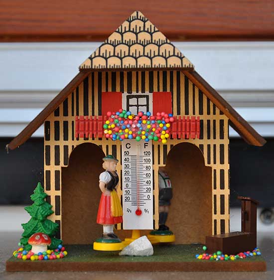 Painted German miniature house with two figures rotating around